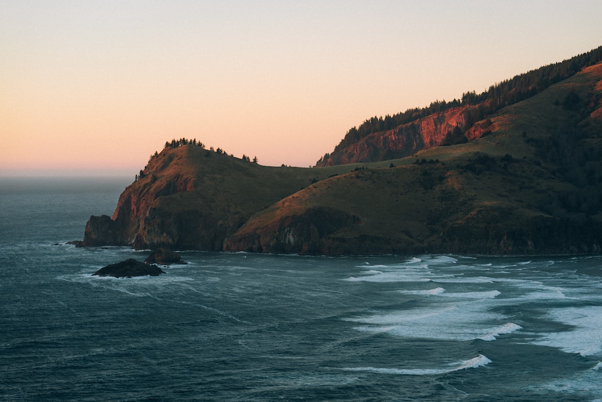 God's Thumb, a natural outcropping jutting outward into the Oregon coastline at sunset